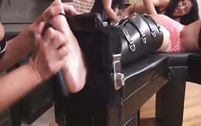 Group of BDSM Latina lesbians tickling a bound friend to see her discomfort level